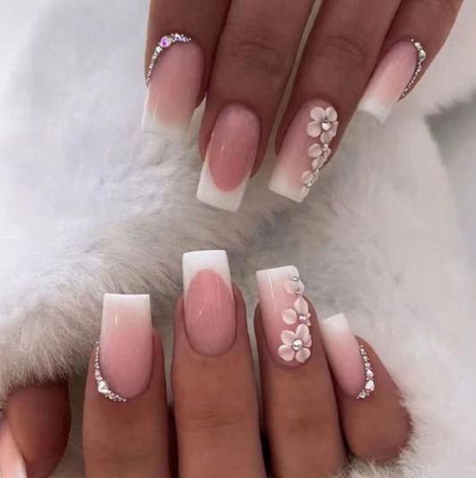 Manicura francesa con punta blanca adornada con flores de cerezo