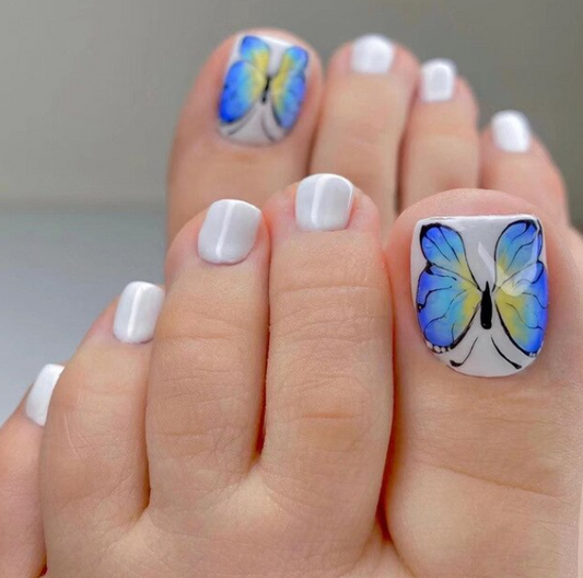 Prensa blanca de mariposa azul en las uñas de los pies